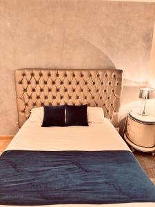 a bedroom with a large bed with a large headboard at Logis Hôtel Saint Martin in Orléans