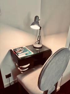 a desk with a lamp and a chair next to a desk at Logis Hôtel Saint Martin in Orléans +22 photos