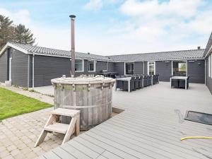 a patio with a wooden barrel and a table at 5 star holiday home in Øster Assels in Øster Assels
