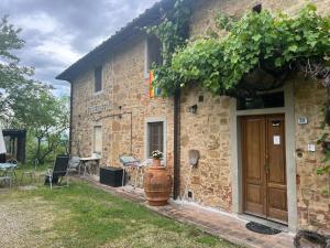 Casa de piedra con puerta de madera y mesa en Country House Il Covo della Civetta, en Barberino di Val d'Elsa