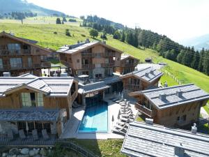 an aerial view of a resort building with a swimming pool at ZAGLGUT Premium Hotel & Chalets, Zell am See-Kaprun - Wellness & Infinity Pool, Air Conditioning, Panoramic Views & Summer Card Included in Kaprun