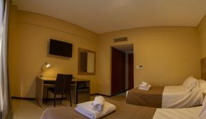 a hotel room with two beds and a desk at Hotel Telepostal Congreso in Buenos Aires
