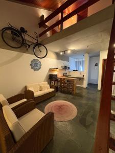 una sala de estar con una bicicleta colgada en la pared en Loft charmoso bem no centro, en São Sebastião