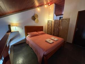 a bedroom with a bed with two towels on it at Loft charmoso bem no centro in São Sebastião