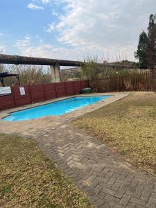 a swimming pool in a yard next to a fence at Indumiso 80 in Newcastle