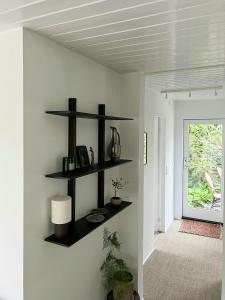 a room with black shelves on the wall at Wooden House With Balinese Vibes At Maglesø 