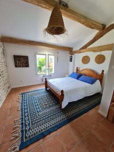 a bedroom with a bed and a blue rug at Les volets bleus in Brie-sous-Mortagne