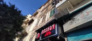 ein Ladenschild an der Seite eines Gebäudes in der Unterkunft Magdalena Haus in Alexandria