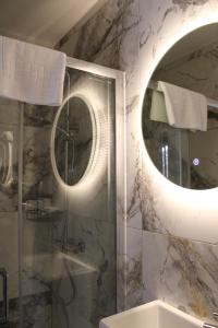 Un baño con espejo redondo y ducha. en MOXIE LUXURY APARTMENTS, en Belfast