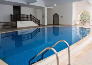 a large swimming pool with blue water in a building at Borj Dhiafa in Sfax