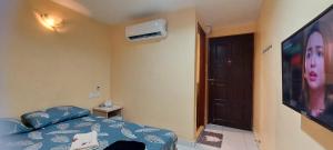 a bedroom with a bed and a television with a woman at RELAX HOTEL in Sungai Petani +9 photos