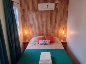 a small bedroom with a bed with two pillows at Complejo Phira in Puerto Pirámides