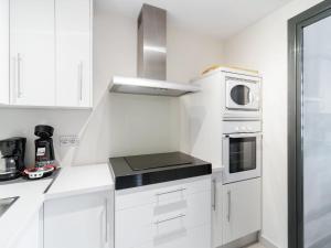 een witte keuken met witte kasten en een magnetron bij Belvilla by OYO Valle del Este in El Esparragal