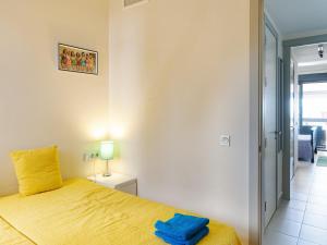 een slaapkamer met een geel bed met een blauwe handdoek erop bij Belvilla by OYO Valle del Este in El Esparragal +35 foto's