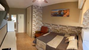 a bedroom with a bed and a brick wall at Promar Playa 255 in La Pineda