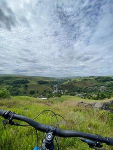 a bike parked on a grassy hill with a view at The Barn, Holden gate Farm Todmorden in Todmorden +8 photos