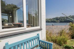 a blue bench sitting in front of a window at Kiln Cottage in Fowey