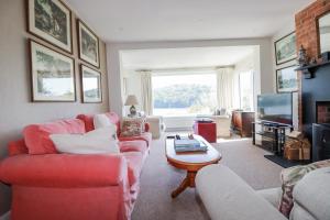 a living room with a red couch and a tv at Kiln Cottage in Fowey