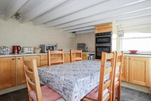 a kitchen with a table and chairs and a table and a table and a kitchen at Kiln Cottage in Fowey