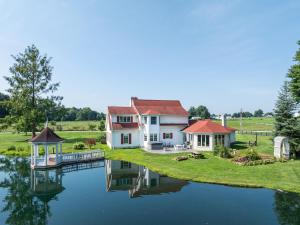 a large house sitting on top of a body of water at Country Cottage in Apple Creek