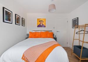 a bedroom with a bed with orange pillows and a ladder at The Grand Southampton Stay, Sleeps 12 in Southampton