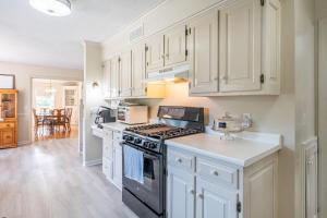 a kitchen with white cabinets and a stove top oven at Country Cottage in Apple Creek