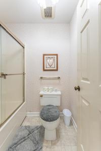 a bathroom with a toilet and a picture on the wall at Country Cottage in Apple Creek +44 photos