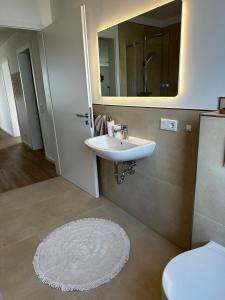 a bathroom with a sink and a mirror at Ferienwohnung an der Windmühle in Horn-Bad Meinberg +8 photos