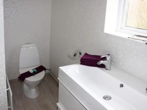 a white bathroom with a toilet and a sink at 4 star holiday home in Söderåkra in Söderåkra +7 photos
