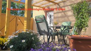 a patio with a table and chairs and flowers at Kim Ferienwohnung B in Sömmerda