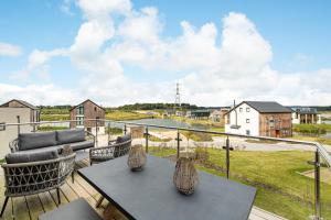 d'une terrasse avec 2 tables et des chaises sur un balcon. dans l'établissement Jurassic BR26 Silverlake Dorset, à Warmwell