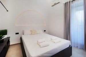 a bedroom with a white bed with two pillows on it at KELIFOS Blue in Pefkochori