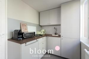 a kitchen with white cabinets and a microwave at Loft indépendant avec parking privé in Nancy