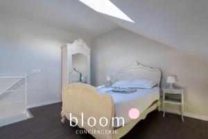 a white bedroom with a bed and a mirror at Loft indépendant avec parking privé in Nancy