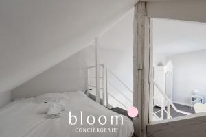 a white bedroom with a bed and a ladder at Loft indépendant avec parking privé in Nancy