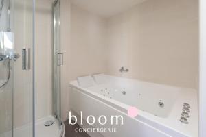 a white bathroom with a tub and a shower at Loft indépendant avec parking privé in Nancy +8 photos