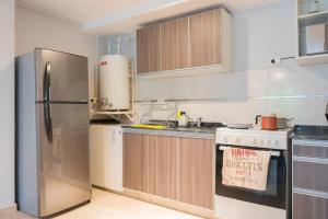 Il comprend une cuisine équipée d'un réfrigérateur en acier inoxydable et d'une cuisinière. dans l'établissement Patagonia Queen, à Concepción