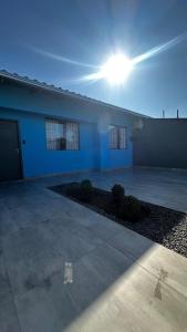 a house with the sun shining on the side of it at Casa Azul, Privativa, Confortável, AR, Wi-Fi in Joinville
