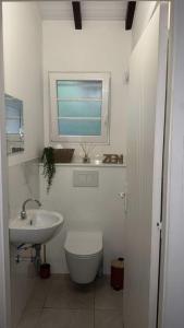 a bathroom with a sink and a toilet and a window at Appartement Elya Anse à l âne Vue Mer in Les Trois-Îlets