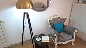 a room with a chair and a table with a lamp at La perla di Caserta 2 in Caserta