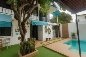 a house with a swimming pool and a tree at Costa Verde Hostal in Manta
