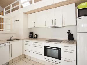 a white kitchen with white cabinets and appliances at 8 person holiday home in Brovst-By Traum in Brovst +34 photos