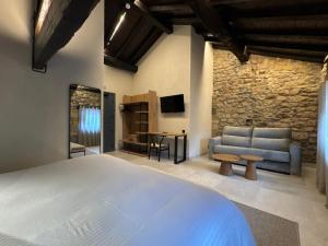 a bedroom with a bed and a couch and a tv at Hotel El Paraíso del Pas in Barcenilla