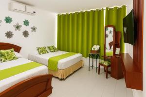 a bedroom with two beds and a green curtain at Costa Verde Hostal in Manta +24 photos