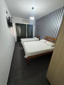 a room with two beds and a television in it at Köşem Motel Ören in Burhaniye