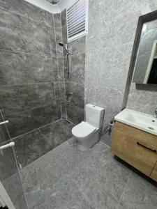 a bathroom with a shower and a toilet and a sink at Köşem Motel Ören in Burhaniye