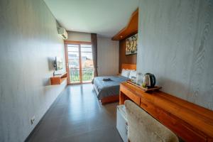 a hotel room with a bed and a balcony at ODA Guest House Umalas in Kerobokan