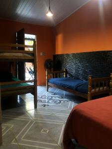 une chambre avec deux lits et un mur de briques dans l'établissement Macondo Hostel Itamambuca, à Praia de Itamambuca