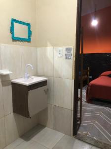 La salle de bains est pourvue d'un lavabo et d'un lit dans la chambre. dans l'établissement Macondo Hostel Itamambuca, à Praia de Itamambuca
