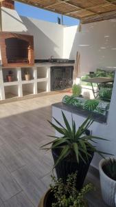 a patio with potted plants and a fireplace at villa pools bbq lounge in Oujda